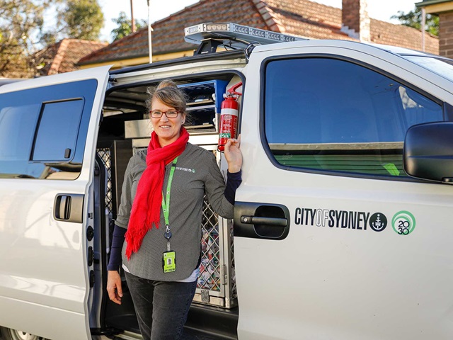 A woman stands alongside a van.