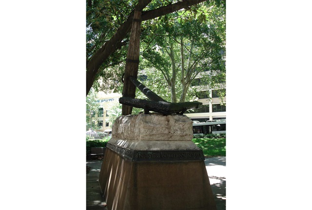 Large ships anchor on stone plinth. 