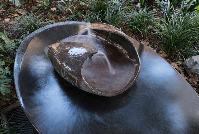 Top down view of a bowel shaped copper fountain spurting water
