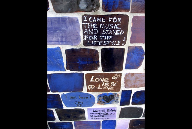 Wall clad in glazed tiles with writing on random tiles
