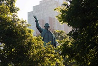 A larger than life bronze statue of Captain James Cook rises from between a group of trees in Hyde Park