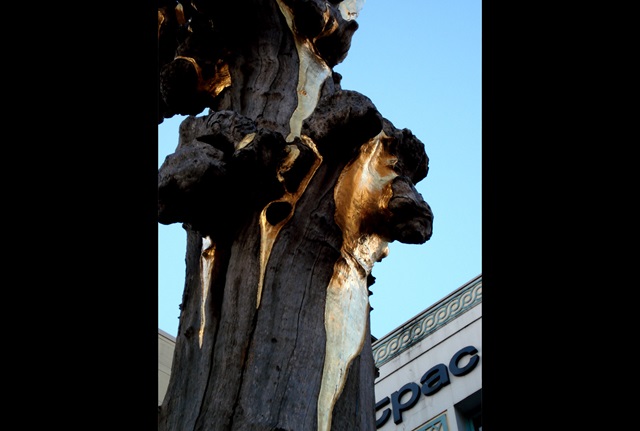 Close up of gold leaf  on a a sculpture made from the trunk of a tree.