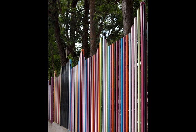 A highly coloured metal school fence with posts of various heights