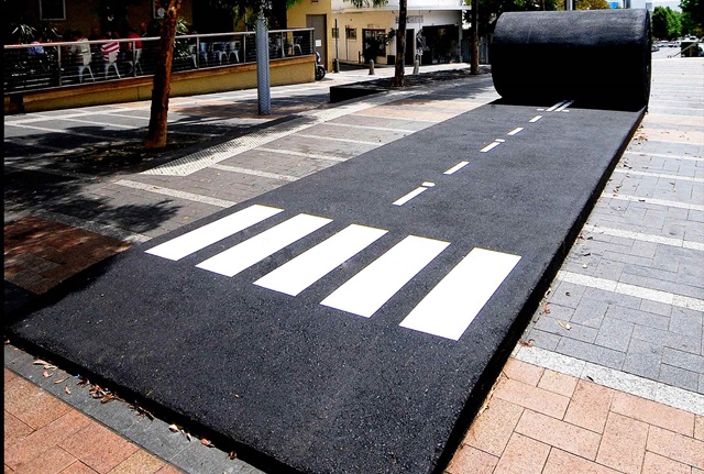 Sculpture made to look like a giant roll of bitumen, unravelling like a rolled out carpet.