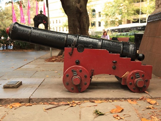  Bronze cannon painted black on a red base that belonged to the H.M.S. Sirius, flagship of the First Fleet.