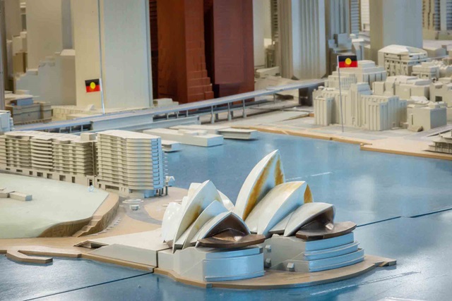 A scale model of the Sydney Opera House and surrounding city buildings, with two Aboriginal flags visible in the background.