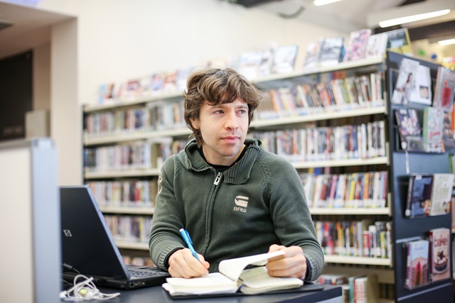 Young man writing in a book