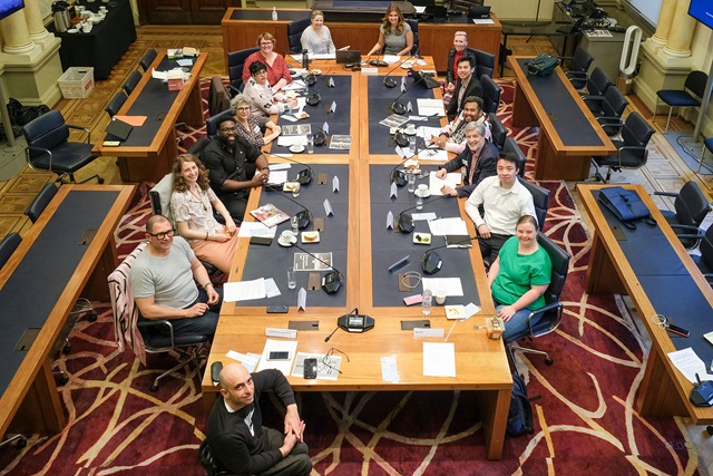 Inclusion advisory panel members sitting around the table, facing the the camera in the Council chamber