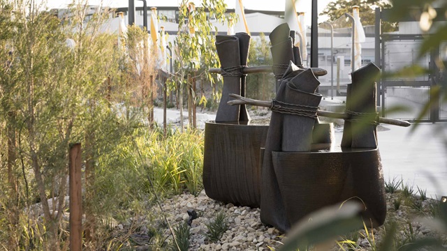 2 oversize bronze cast bangala, or Eora bark water carriers situated in a wetland setting at Gunyama Park Aquatic and Recreation Centre.