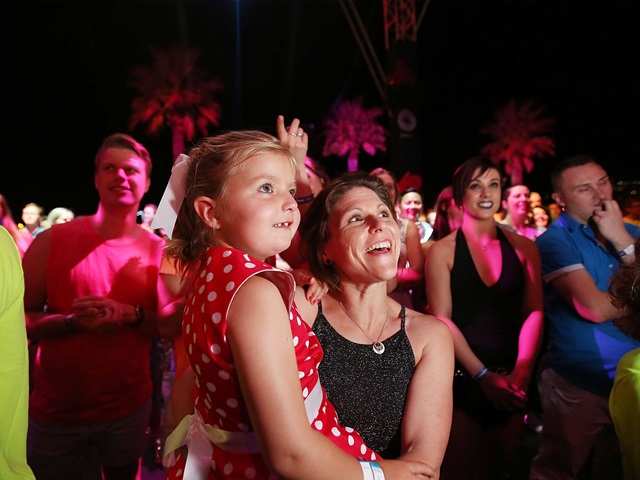 Woman holding a small child watching fireworks at night