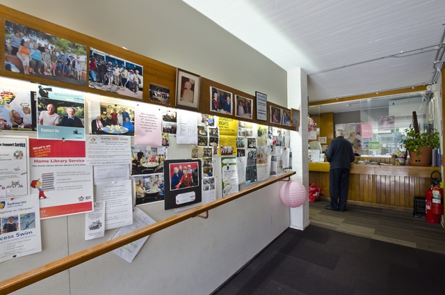 A noticeboard filled with flyers at Cliff Noble Community Centre.