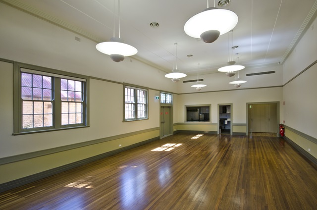 A large hall with high ceilings and art deco ceiling lights.