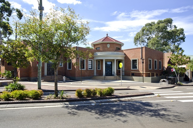View of the Community Centre from the street with trees surrounding the building.