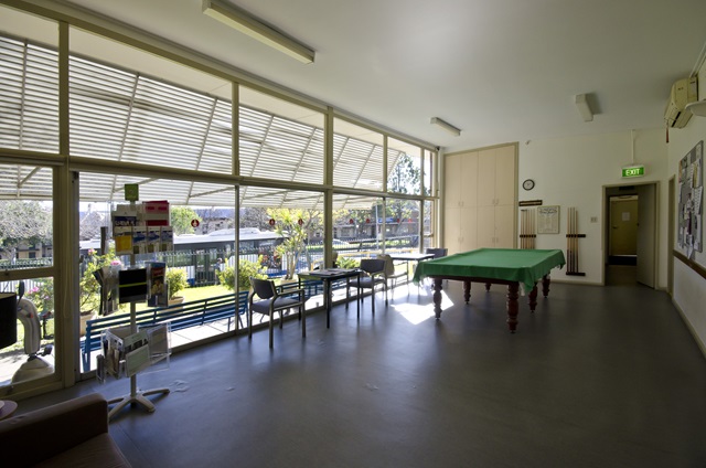 Large room with floor to ceiling windows and a pool table.
