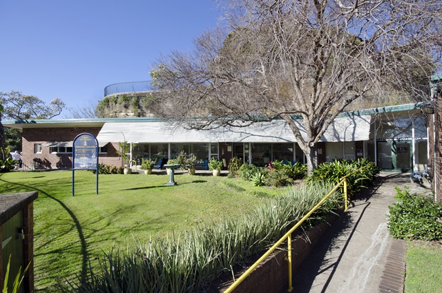 The Harry Jensen Community Centre, with a grassy area and tree in the front garden.
