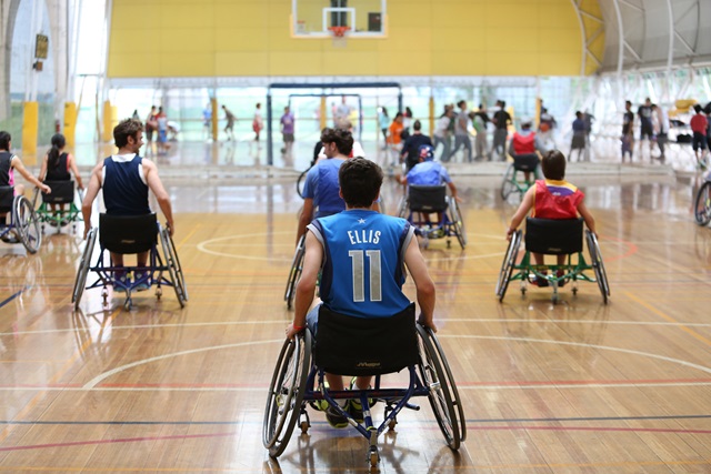 People in wheelchairs playing basketball.