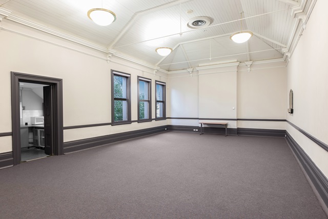 A large room with high ceilings and a carpeted floor.