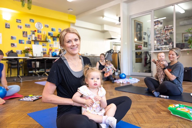 Women with children sitting on yoga mats