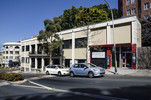 The outside of the building with cars on the street.