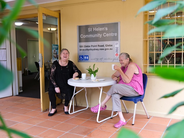 Two people enjoying a cuppa on the porch at the front of the centre.