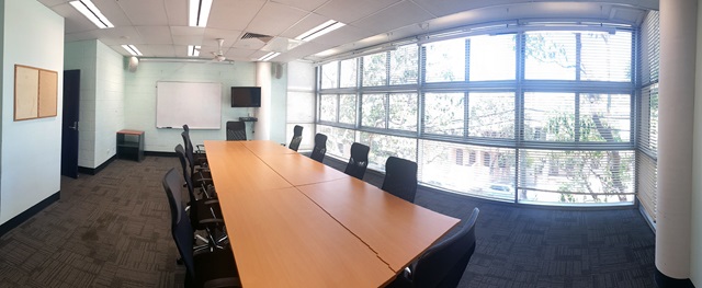 Large bright meeting room with large table surrounded by chairs