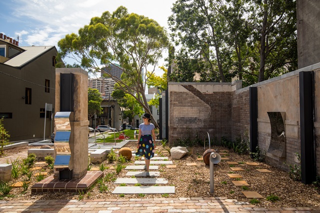 A lady walks through the community garden.