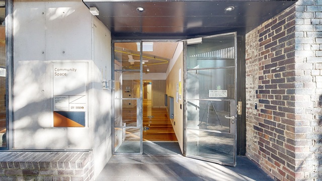 The entrance to a brick building with a glass door. l