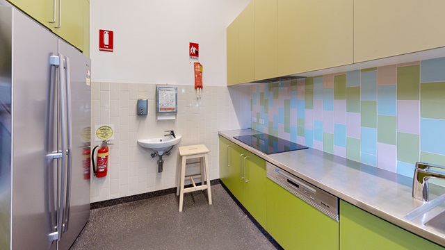 A kitchen with a sink and a refrigerator.