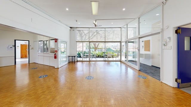 polished floors with floor to ceiling windows and an opened blue door