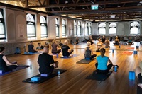 A group of people doing yoga in a large room