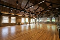 An empty room with wooden floors and windows