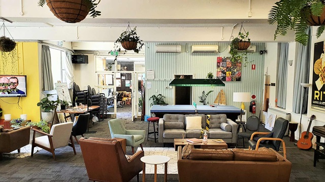 Casual seating area with couches, pool table and TV