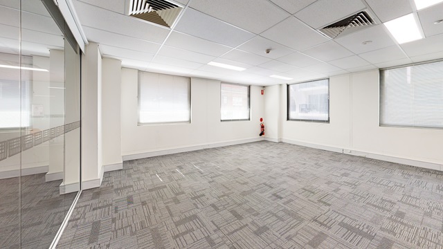 An empty room with glass doors and windows.