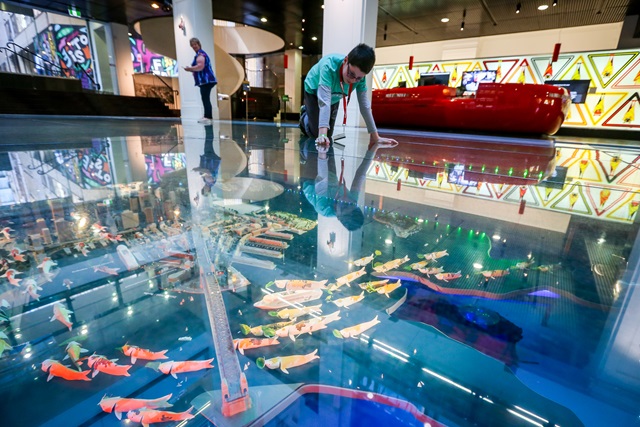A child looking at a colourful floor inside a building.