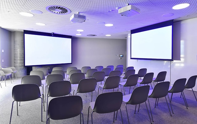 Theatre style chairs with 2 large displays on walls