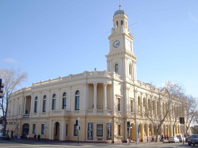 A cream-coloured heritage building with arches and tall clock tower.
