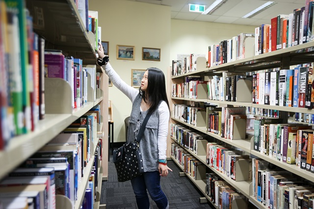 Girl browsing a bookshelf at Ultimo Library
