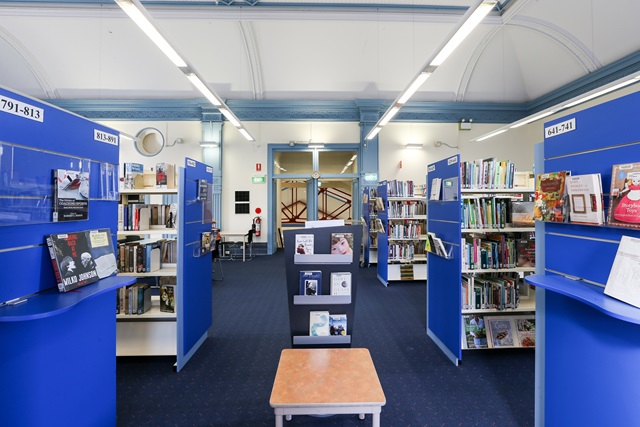View of blue highlighted bookshelves inside Waterloo Library.