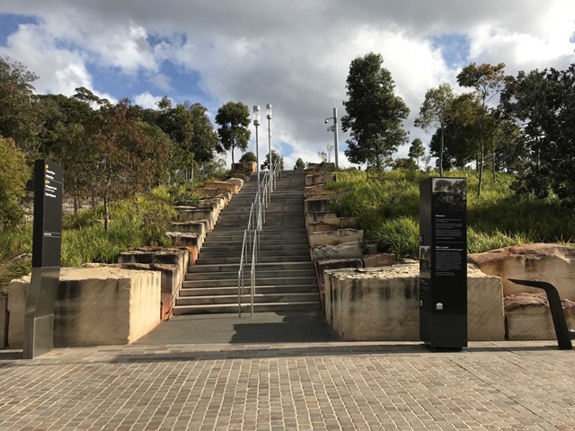 A long staircase climbing high with trees on either side of it.