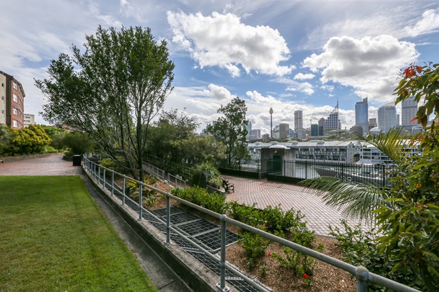 Grass area on the left and on the right is a fence and garden bed