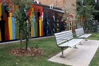 A vew of park benches and the new Indigenous art work 'Wall of Humanity' designed by artists Bronwyn Bancroft and Dales Jones-Evans, and painted by local children, Hugo Street Reserve.