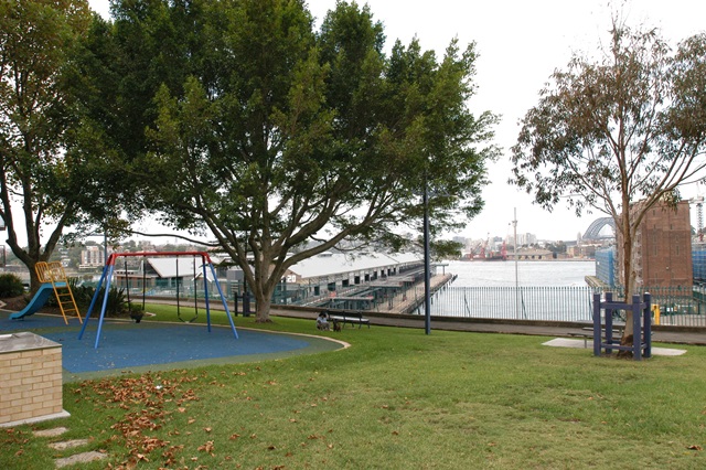 The playground in James Watkinson Park with view of Sydney Harbour and Sydney Harbour Bridge.