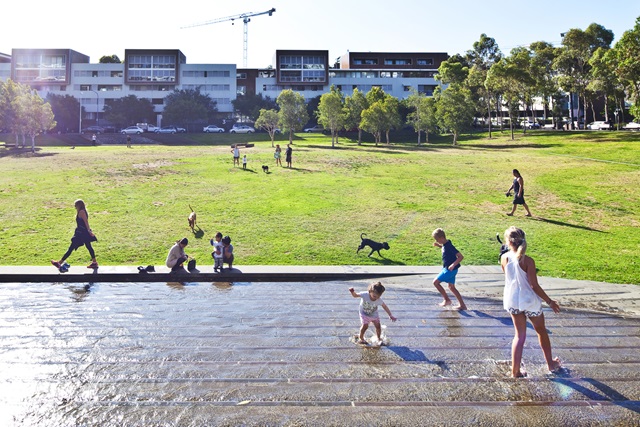 Children playing in water feature on a sunny day in Joynton Park.