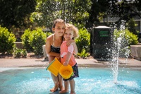 2 young children playing in the water feature of May O'Brien Reserve