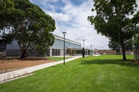 A very green grassy area dotted with trees in Perry Park.