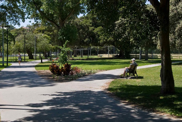 Man sitting on a park bench enjoying the sunshine and open space