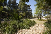 A landscaped garden area bordering a cobbled stone pathway through Southern Cross Reserve.