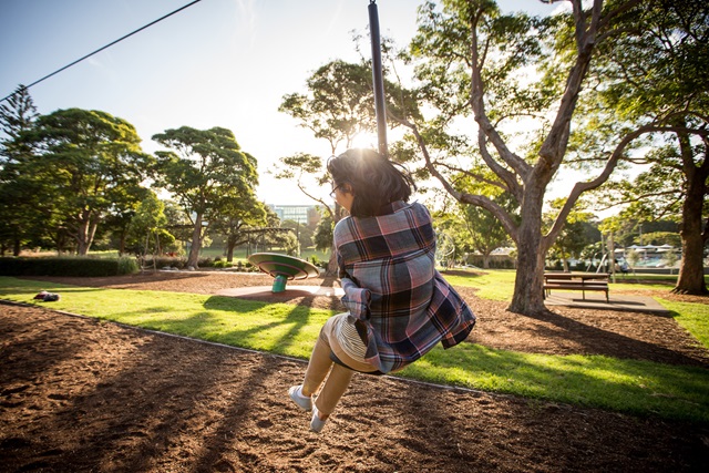 A woman playing on a flying fox at Victoria Park.