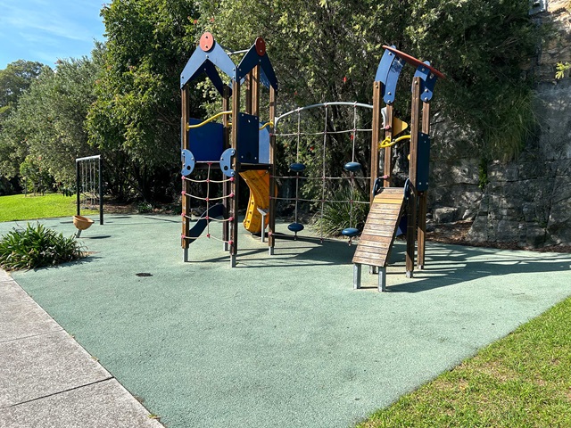 A playground with a slide and a climbing frame.