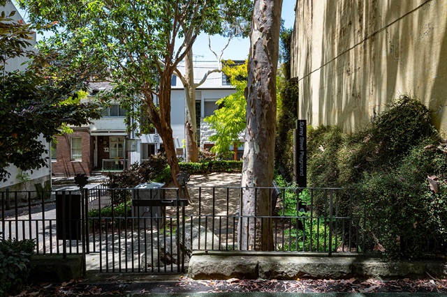 A person sitting on a bench in a park.